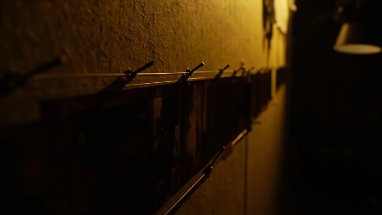 Framed film-strip contact sheets pinned to a dark corkboard.